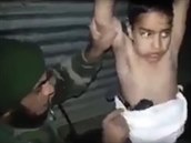 Irácký voják deaktivuje nálo na tle sedmiletého chlapce.