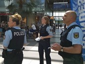 Nmetí policisté vybírají dobrovolníky na berlínském Hlavním nádraí.