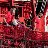 Pracovníci Červeného kříže vyloďují v Evropě těhotnou migrantku.
