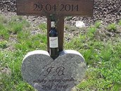 Památník zohyzdila flaka vína s kyticí luního kvítí.