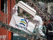 Zamstnanci agentury Frontex vynáejí na italském pobeí rakve s tly lidí,...