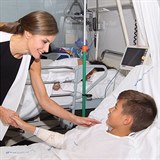 Královna Letizia si podává ruku s malým pacientem.