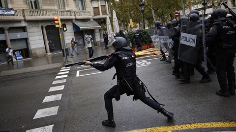 Ozbrojení policisté rozhánějí neozbrojený dav.