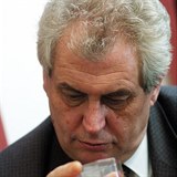 Miloš Zeman kouká okem odborníka na sklenku s alkoholem.