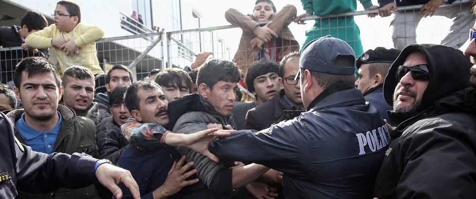 Strkanice mezi eckými policisty a migranty v uprchlickém táboe v Athénách.