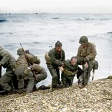 Američtí vojáci si navzájem pomáhají během vylodění v Normandii.