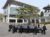 Kimova delegace se slavnou ochrankou mu kteí bí podél jedoucí limuzíny.