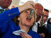 Merkelová si si dopává rybí pochoutku.