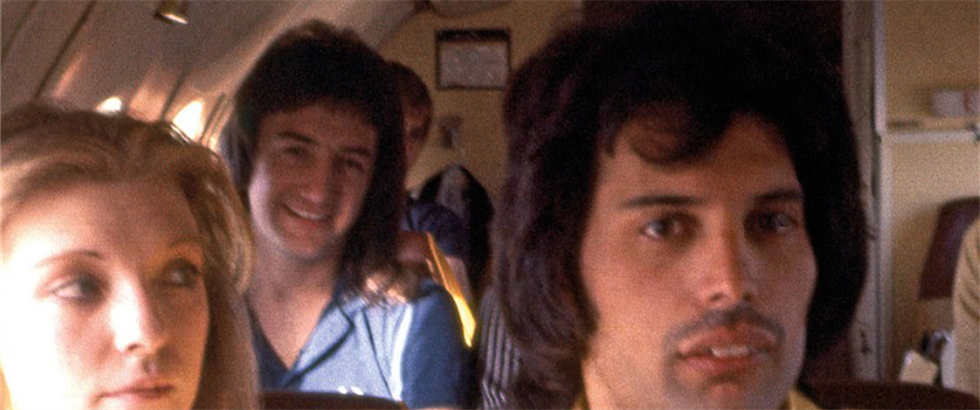 John Deacon (vzadu) a Freddie Mercury bhem soukromého letu.