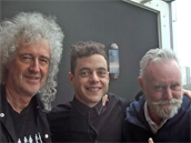 Brian May vlevo, Roger Taylor vpravo pózují s hercem  Ramim Malekem, který si...