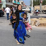 Zdrcená žena odnáší své děti do bezpečí.