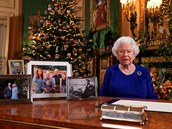 Královna bhem vánoního projevu. Na stole má fotky nejblií rodiny, a na...