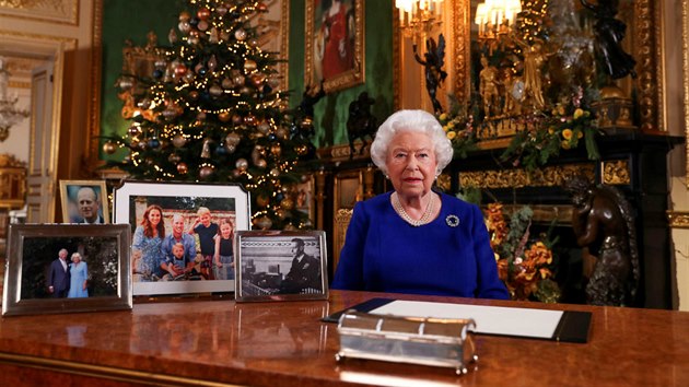 Královna bhem vánoního projevu. Na stole má fotky nejblií rodiny, a na...