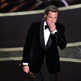 Brad Pitt se radostně natahuje pro svého Oscara.
