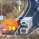 Kamiony projíždějí 14. března 2020 kolem kontrolního stanoviště na dálnici D8...