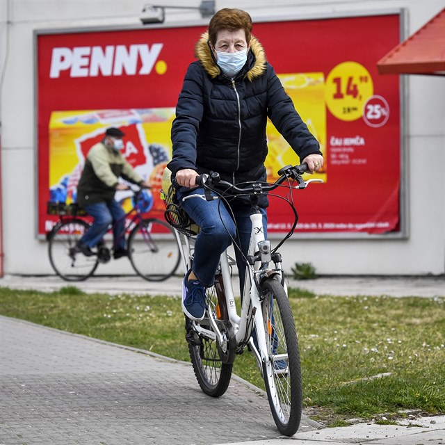 Dchodci na kolech na cest z obchodu s potravinami 19. bezna 2020 v Lys nad...