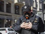 Policista s respirátorem hlídkoval 14. bezna 2020 v centru Prahy.