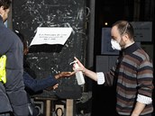 A volunteer sprays hydroalcoholic gel on a voter during the first round of the...