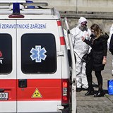 Zdravotníci v ochranných oblecích kontrolují 25. března 2020 v Praze cestující...