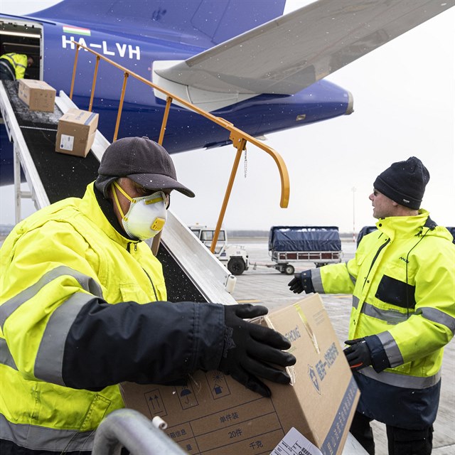 Workers unload boxes containing medical aid and protective materials to combat...