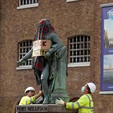 Dělníci demontují Milliganovu sochu.