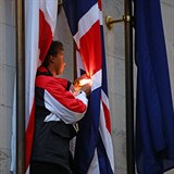 Demonstrant se snaží zapálit britskou vlajku.