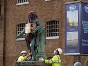 Dlníci demontují Milliganovu sochu.
