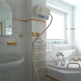 Koupelna s rohovou vanou působí luxusně.