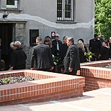 Smuteční hosté čekající před krematoriem.