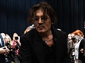 Johnny Depp líbá fanynce ruku.