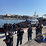 Policie dohlíží na vylodění migrantů.