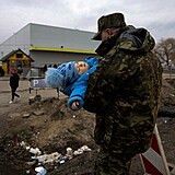 Voják na polské hranici přenáší miminko ukrajinských rodičů.