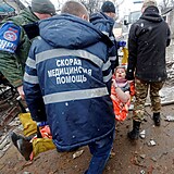 Zraněná ukrajinská žena je odnášena z trosek zbořeného domu v doněcké oblasti.