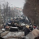 Místní lidé si prohlíží zničené zbytky ruských vojenských vozidel na silnici ve...