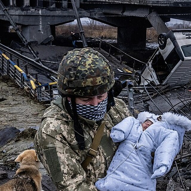 Ukrajinsk vojk zachrauje batole z trosek zcela vybombardovanho msta Ilpin.
