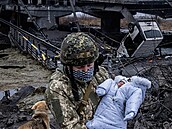 Ukrajinský voják zachrauje batole z trosek zcela vybombardovaného msta Ilpin.