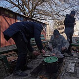 Muži si na ulici v Kyjevě vaří jídlo.