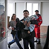 Rodiče běží se zraněným miminkem do nemocnice.