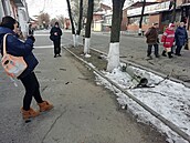 Lidé v Charkov procházejí kolem nevybuchnuté munice.