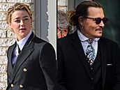 Heard u soudu 13. dubna v bílé košili, černém saku a sepnutých vlasech, Depp v...