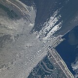 Satelitní snímek ukazuje valící se vodu protrženou přehradou na jihu Ukrajiny.