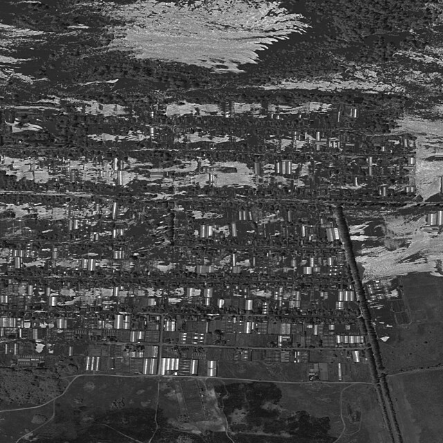 Satelitn snmek ukazuje zaplavenou domy v obytnou oblasti v blzkosti pehrady.