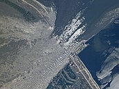 Satelitní snímek ukazuje valící se vodu protrenou pehradou na jihu Ukrajiny.