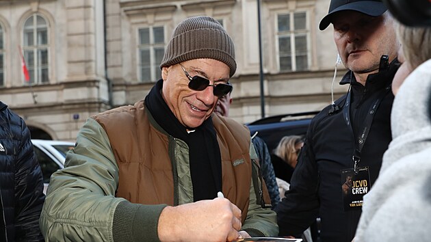 Jean-Claude Van Damme rozdává podpisy.