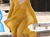 Heidi Klum pechází po plái v nádherném lutém pláovém odvu, který jí dodává...