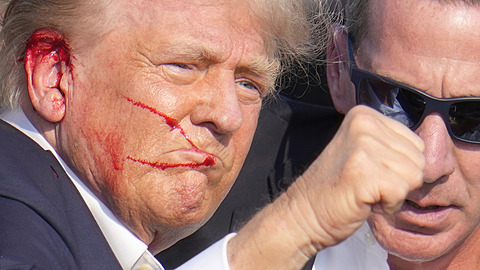 Krvavý Donald Trump zvedá pst na znamení, e je v poádku, zatímco je obklopen...