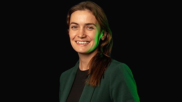 Sarah Haváčová ve studiu Záložky, zelené sako, černé pozadí.