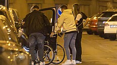 P�átelé pomáhají Patrikovi p�emístit se do auta.