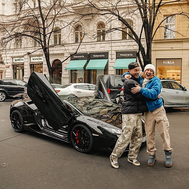 �M�me ho.� Radostn� fotka p�ed zaparkovan�m lamborghini v centru, nov� majitel� p�zuj� a obj�maj� se.