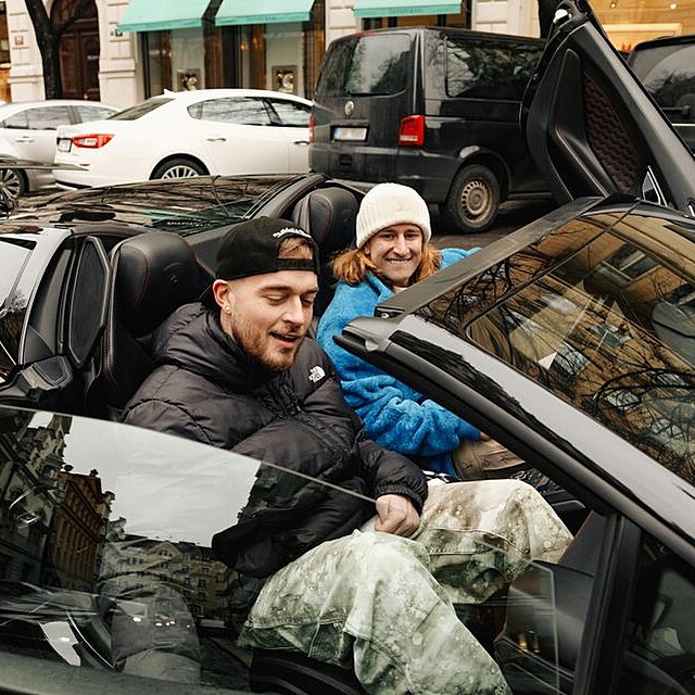 Lamborghini s vyklopen�mi dve�mi na plo�e u pr�myslov�ch budov, B�rik a jeho par��k u auta p�i prvn�ch fotk�ch